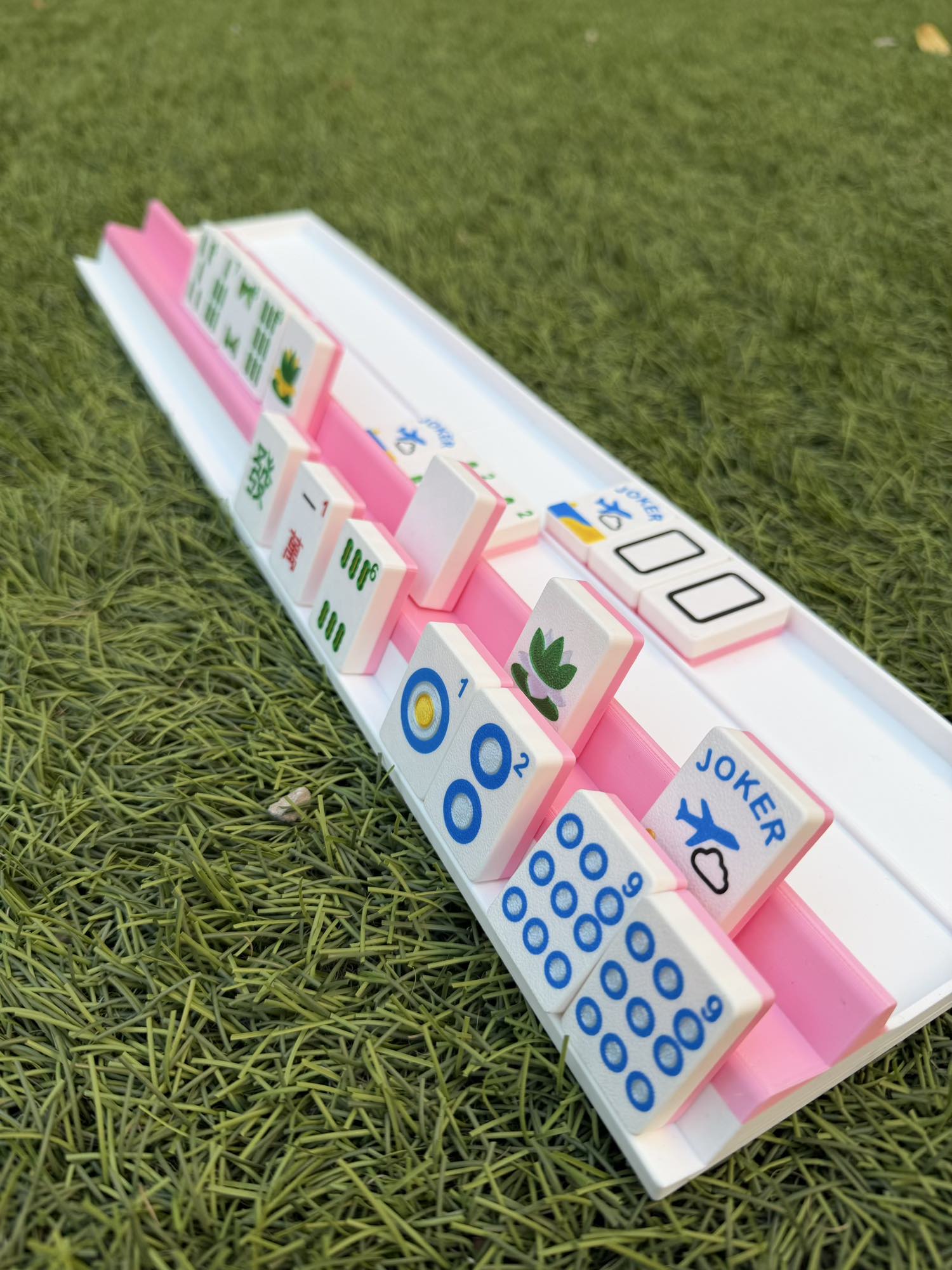 Detail view of a Siamese travel rack holding 28 tiles, showing the compact 3D-printed design.