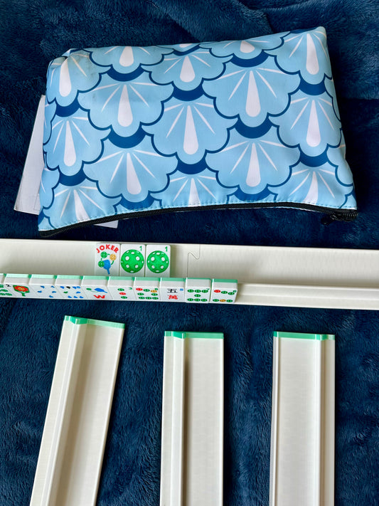 Blue and white patterned pouch on a dark blue surface with dice and game pieces.