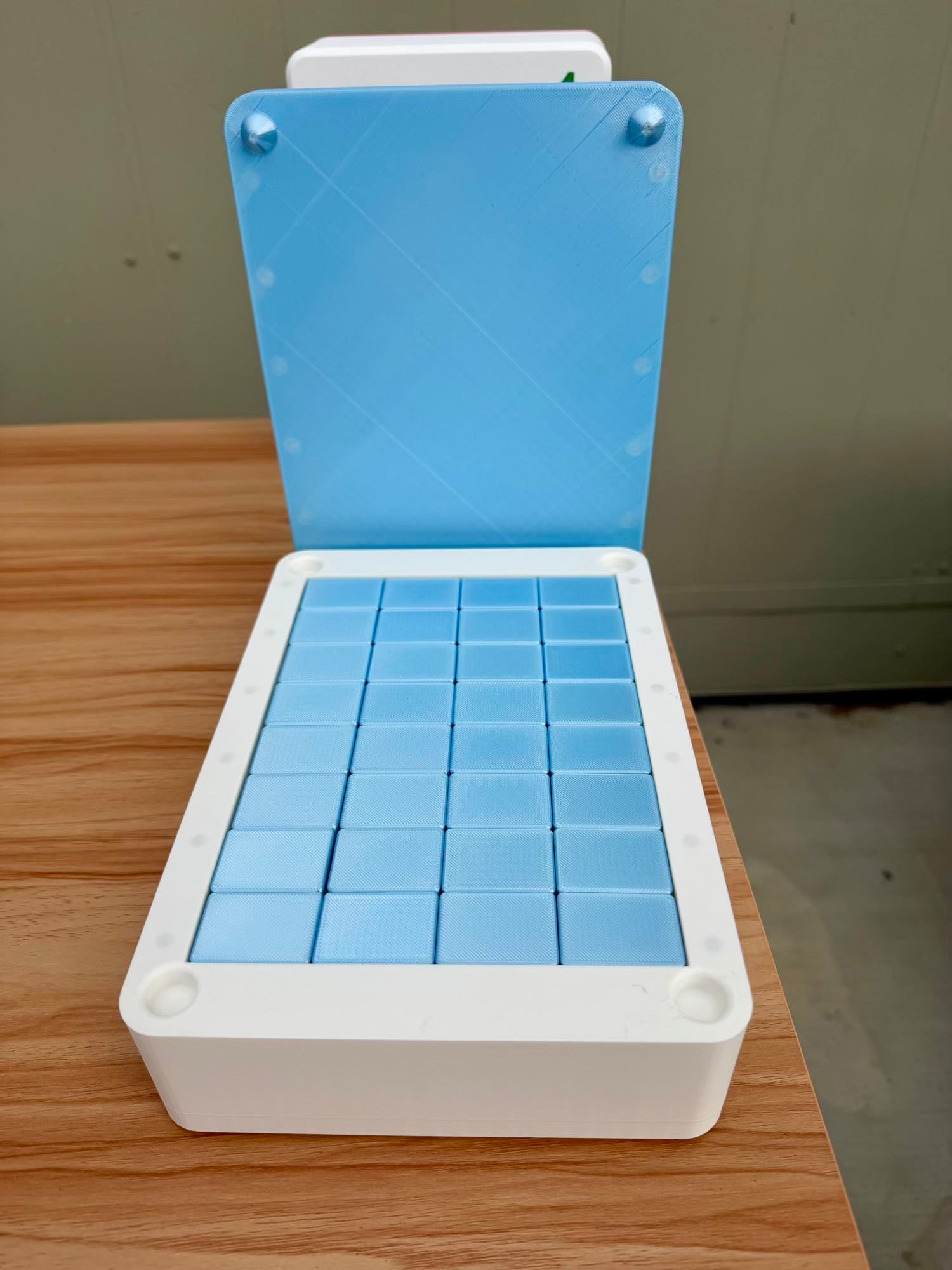 Blue Mahjong Tile tray in a white container on a wooden surface