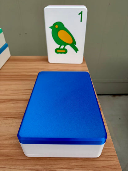 Blue and white tile box with a green bird card on a wooden surface