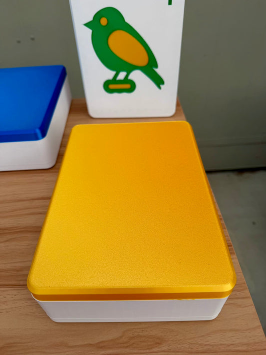Yellow Mahjong tile box with a white base on a wooden surface