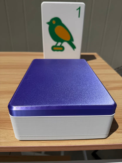 Silk Purple and white box with a card featuring a bird illustration on a wooden surface.