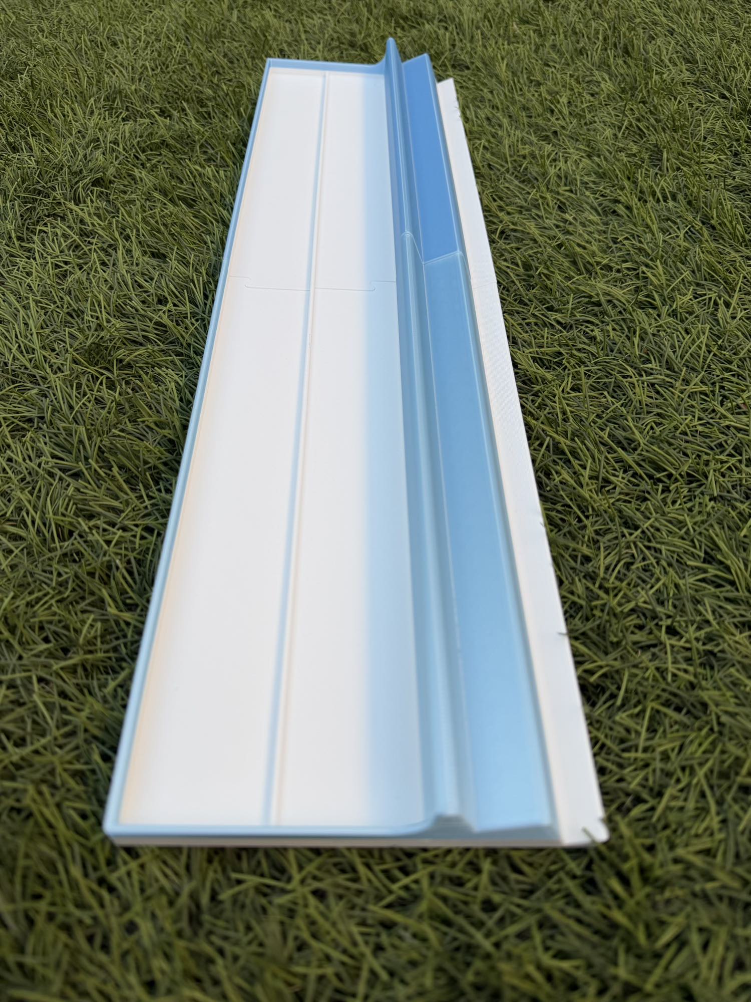 A long, light blue and white travel rack designed for Siamese Mahjong gameplay