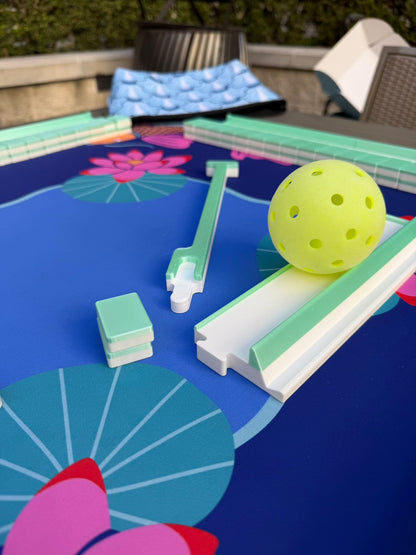 Spools Pickleball mahjong set accessories displayed on a pickleball-themed mat, including racks and gameplay pieces.