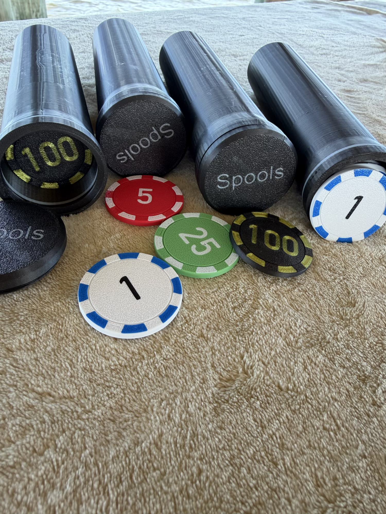 Spools lightweight poker chips grouped together showing different colors and denominations.
