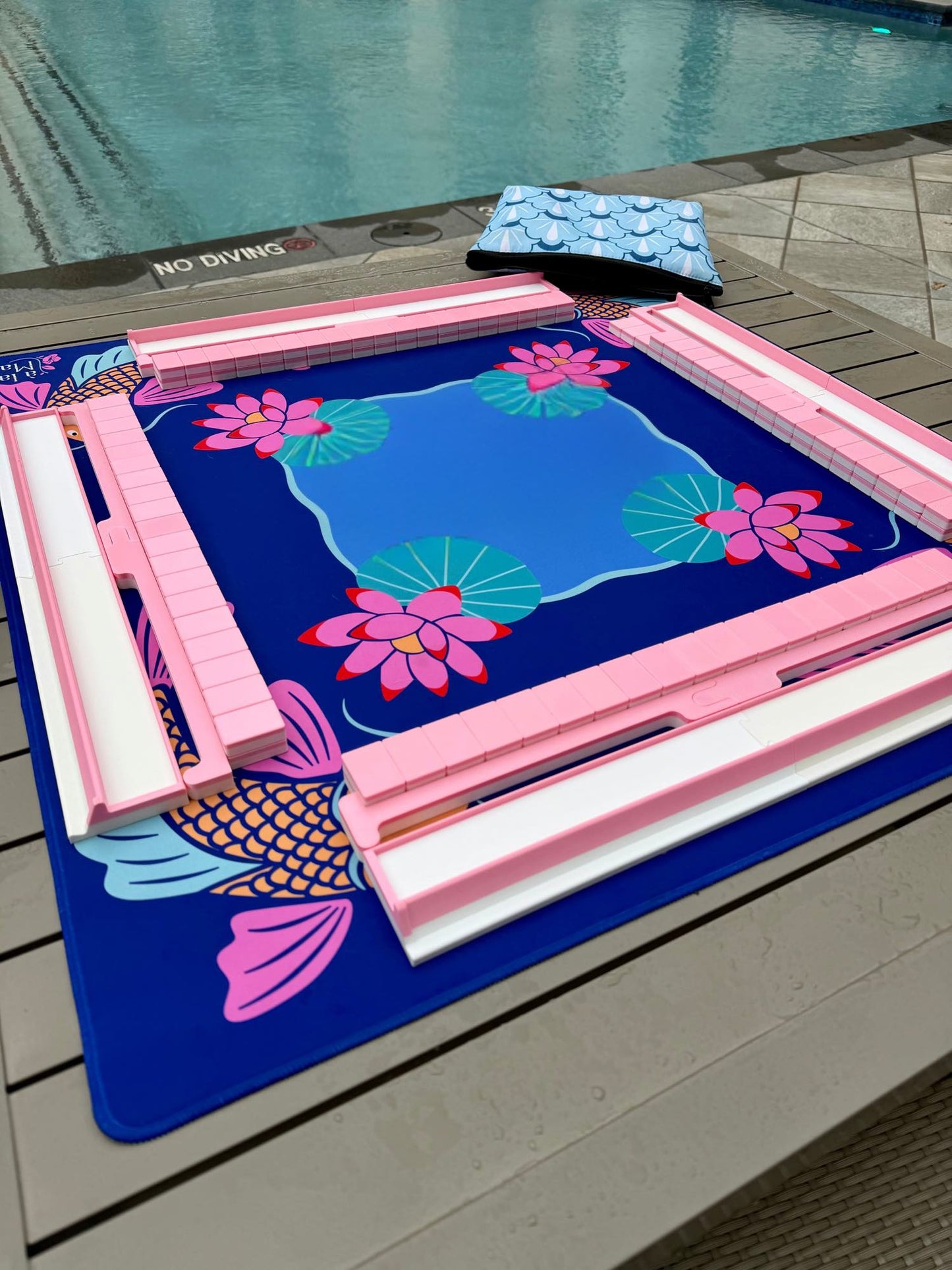 Spools pool mahjong set with pink floating racks and tiles arranged on a pool-themed playing mat.
