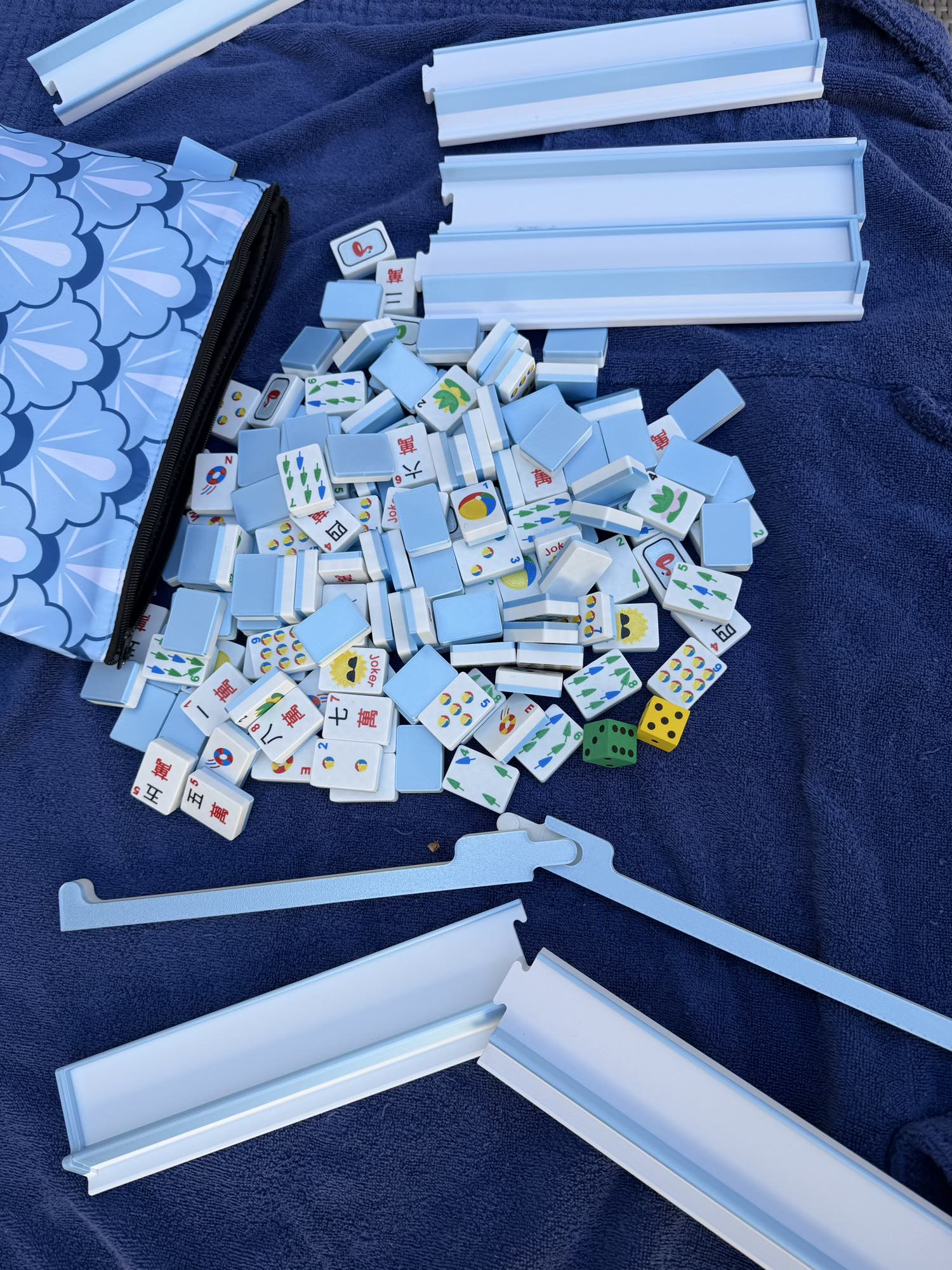 Spools pool mahjong tiles and racks spread out together showing full floating tile set components.
