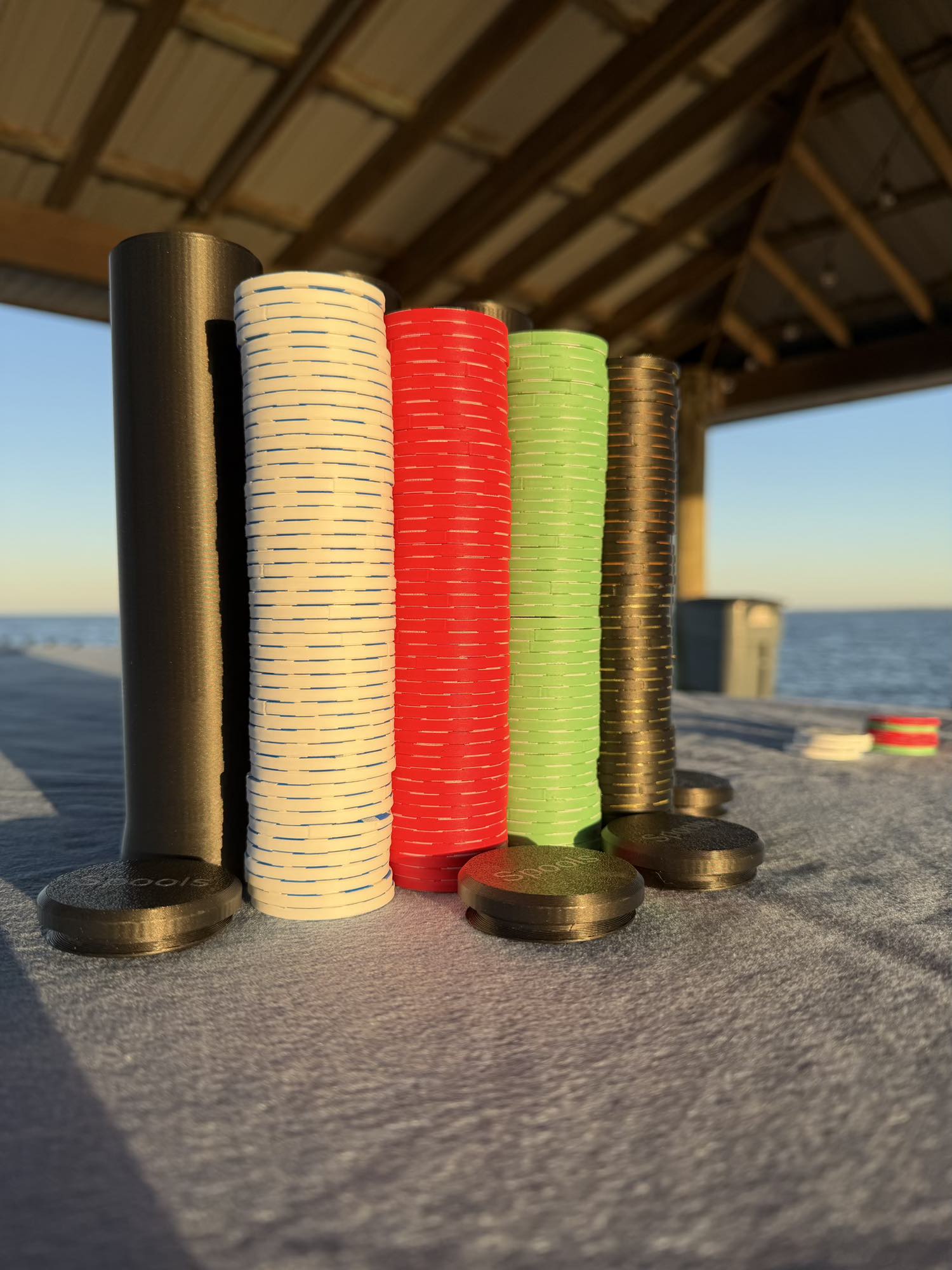 Spools lightweight poker chips stacked in tall columns showing multiple colors and slim chip profile.