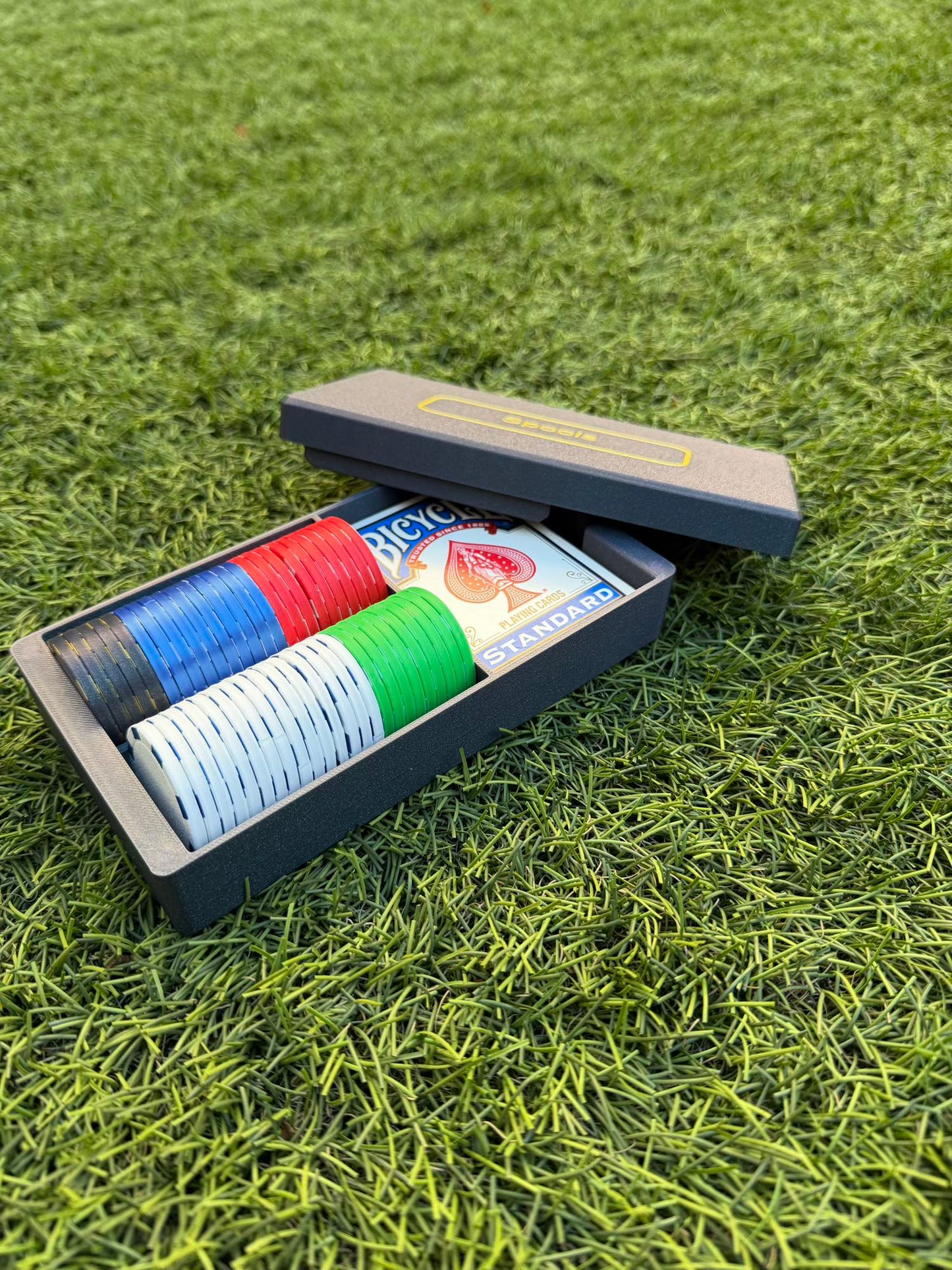 Spools travel poker set opened to show organized rows of lightweight poker chips and playing cards inside the case.
