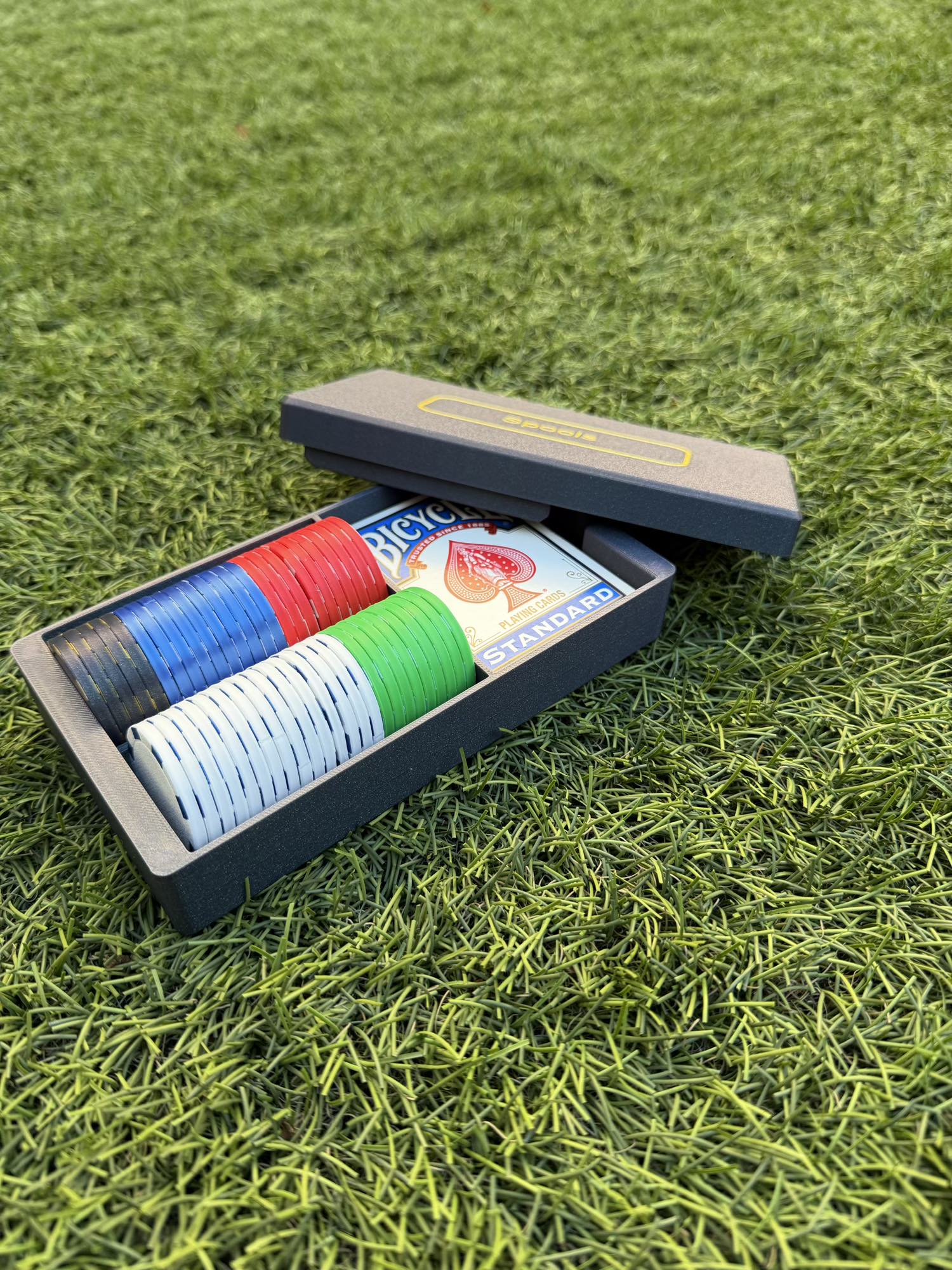 Spools travel poker set opened to show organized rows of lightweight poker chips and playing cards inside the case.
