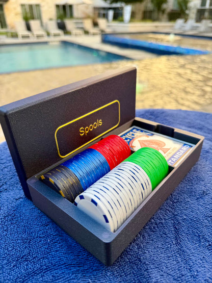 Spools travel poker set opened beside a pool, showing lightweight poker chips and playing cards ready for play.
