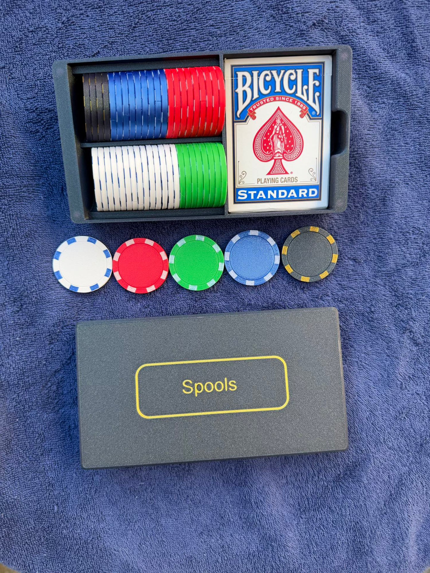 Top-down view of Spools travel poker set showing organized chips, playing cards, and slim carrying case.