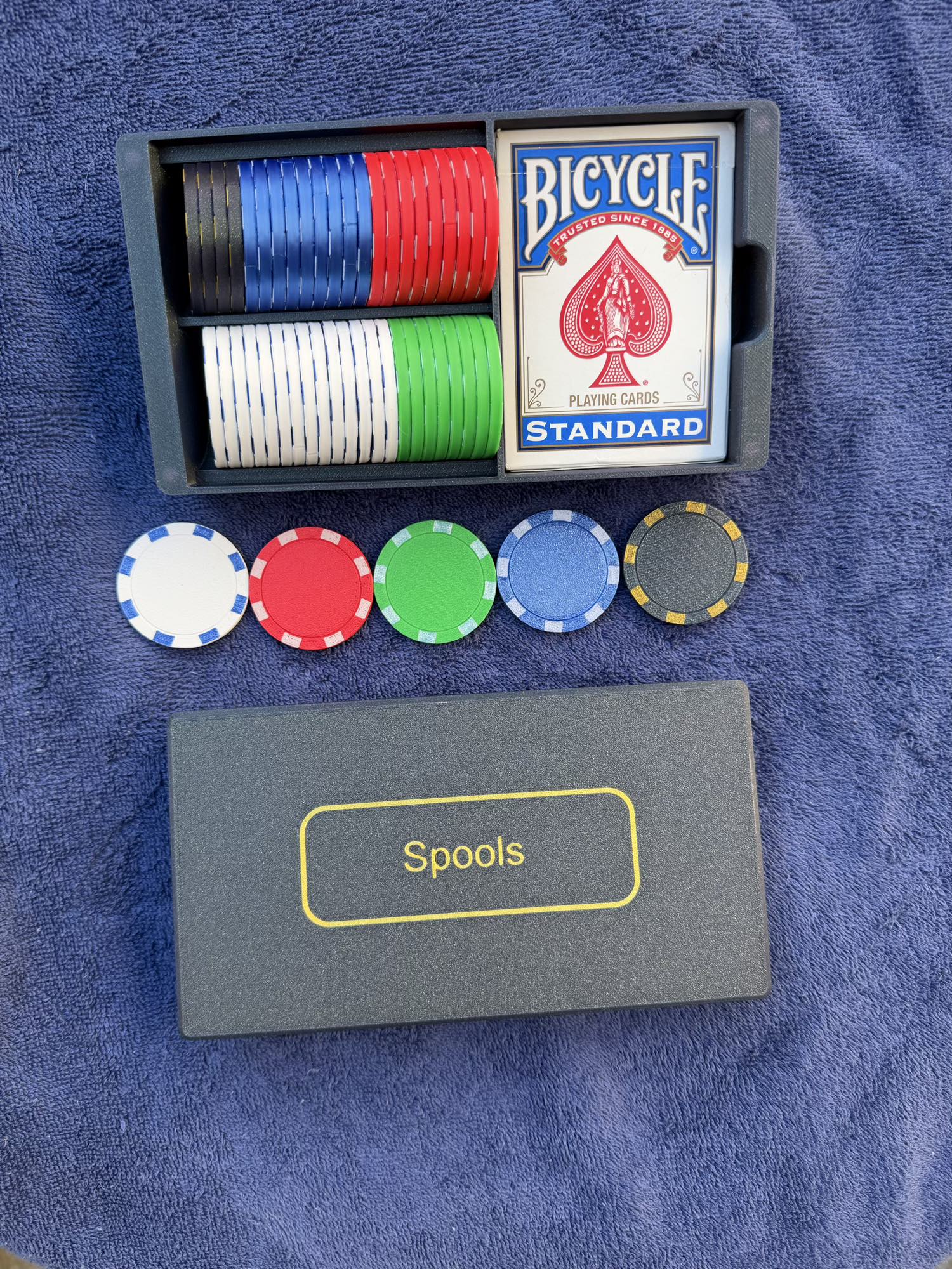 Top-down view of Spools travel poker set showing organized chips, playing cards, and slim carrying case.