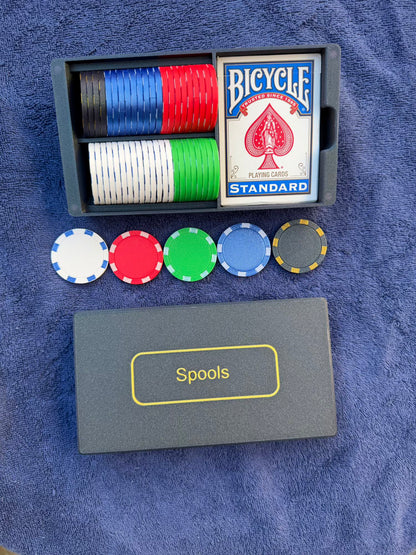 Top-down view of Spools travel poker set showing organized chips, playing cards, and slim carrying case.