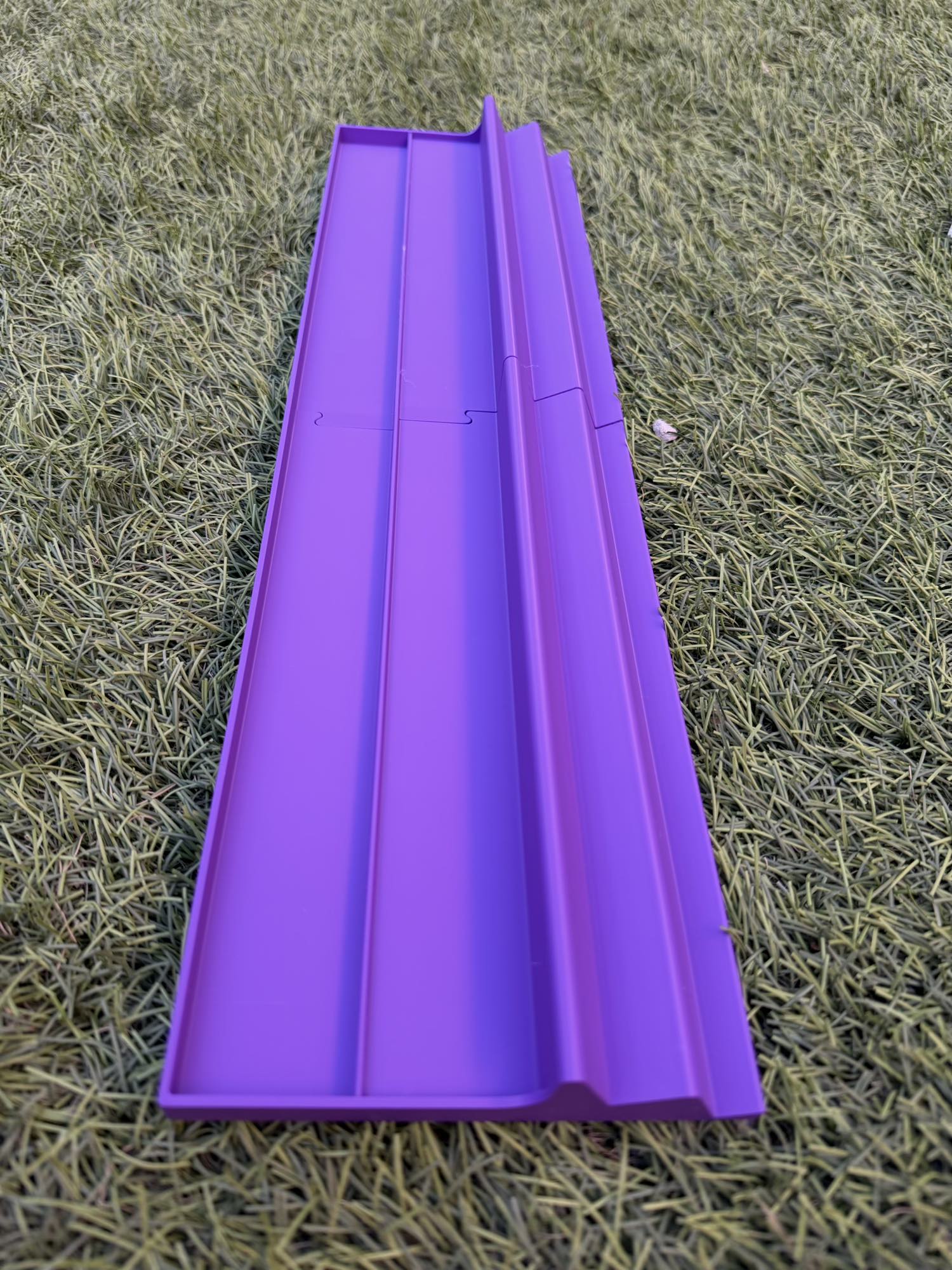 A 3D-printed triple-tier Siamese Mahjong rack in vibrant purple, resting on grass.