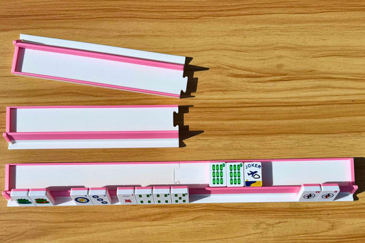 Set of pink and white mahjong tiles on a wooden surface